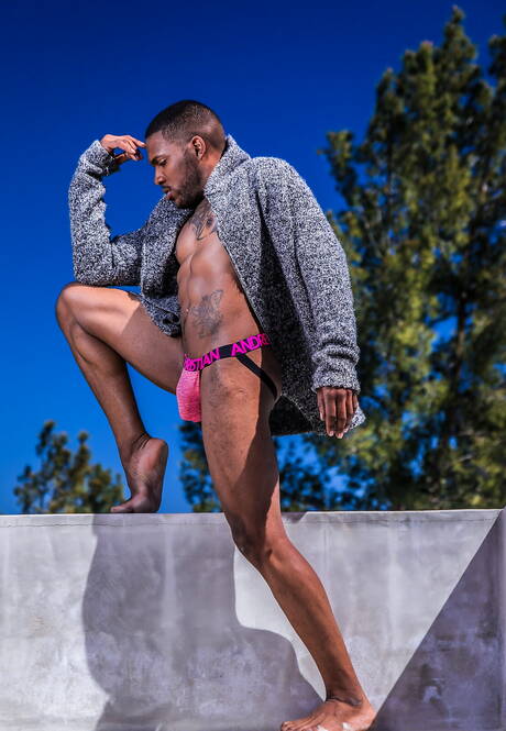 Black muscular Aaron Reese shows a husky body outdoor